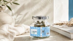 Produtos CBD Portugal com frasco de flores CBD Blue Cheese Doctor CBD, colocado sobre superfície clara com elementos decorativos naturais.
